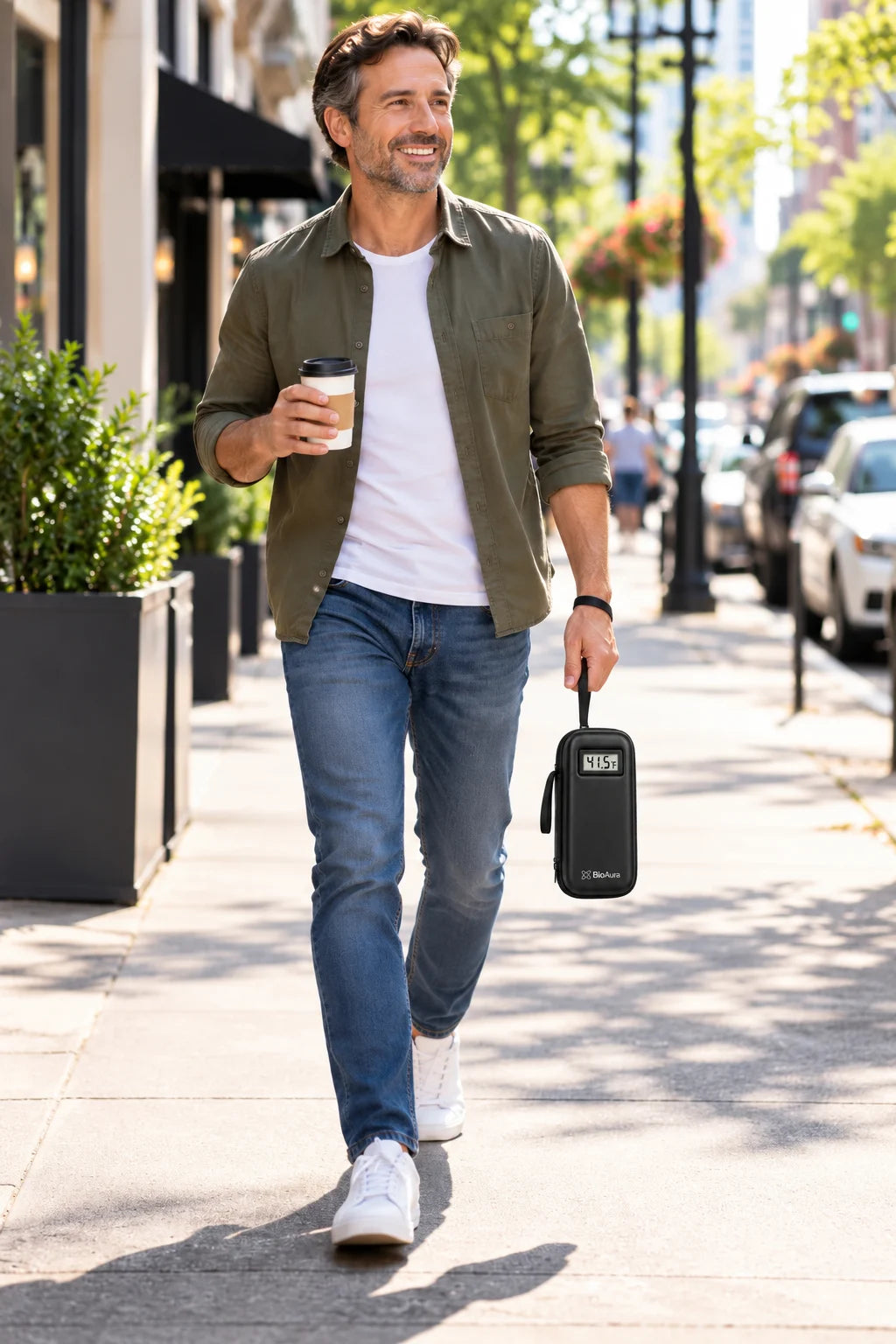 Man walking down a city street with his BioAura Case in hand