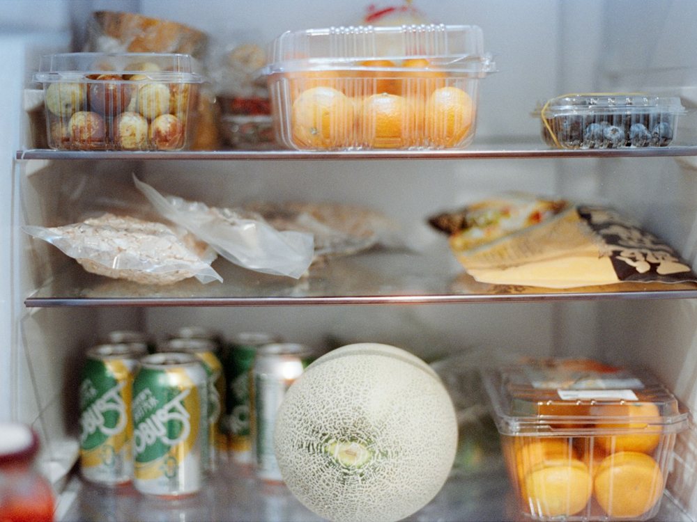 Crowded home fridge shelves full of food